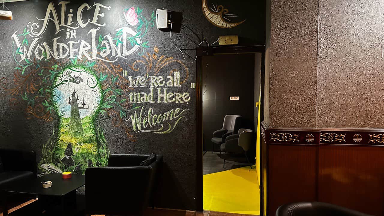 Peinture murale sur le thème d’Alice au pays des merveilles au club de cannabis Alice Valence