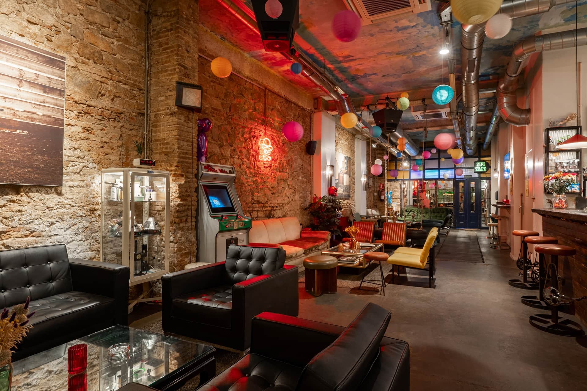 Dans le club social de cannabis Dr. Dou Barcelone, intérieur avec fauteuils en cuir et borne d’arcade rétro