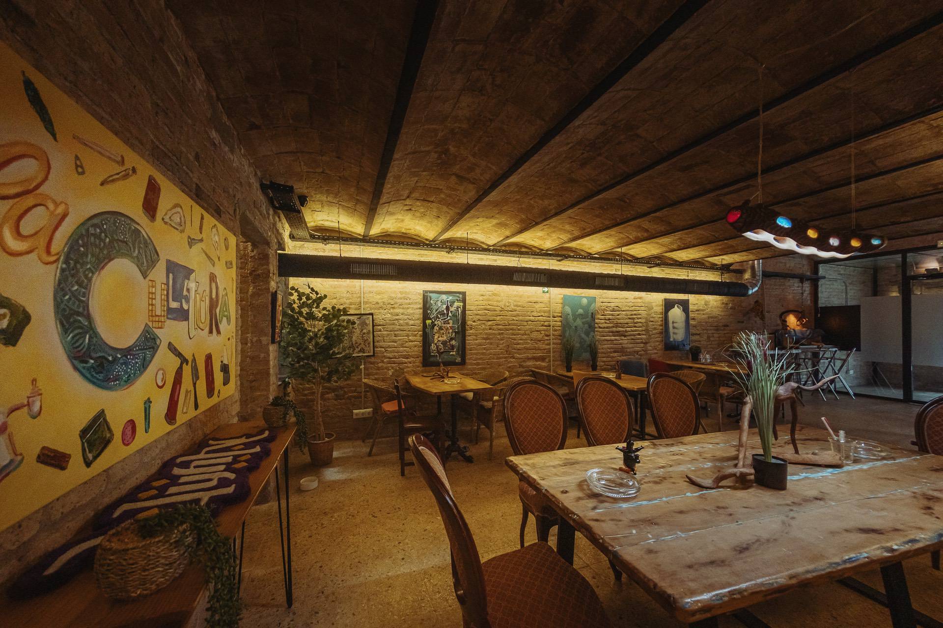 Intérieur créatif du club de cannabis Cultura Barcelone avec fresque murale et espace lounge