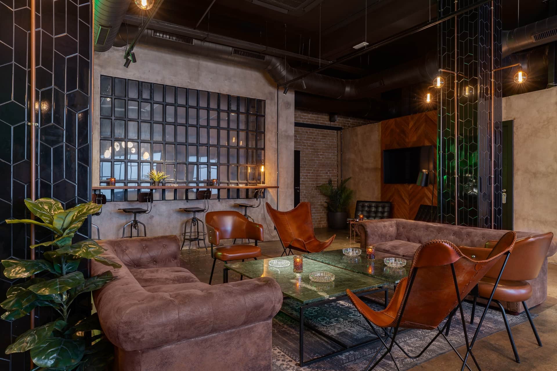 Dr. Resin Barcelone club social de cannabis — lounge moderne avec canapés marron, tables en verre et plantes vertes