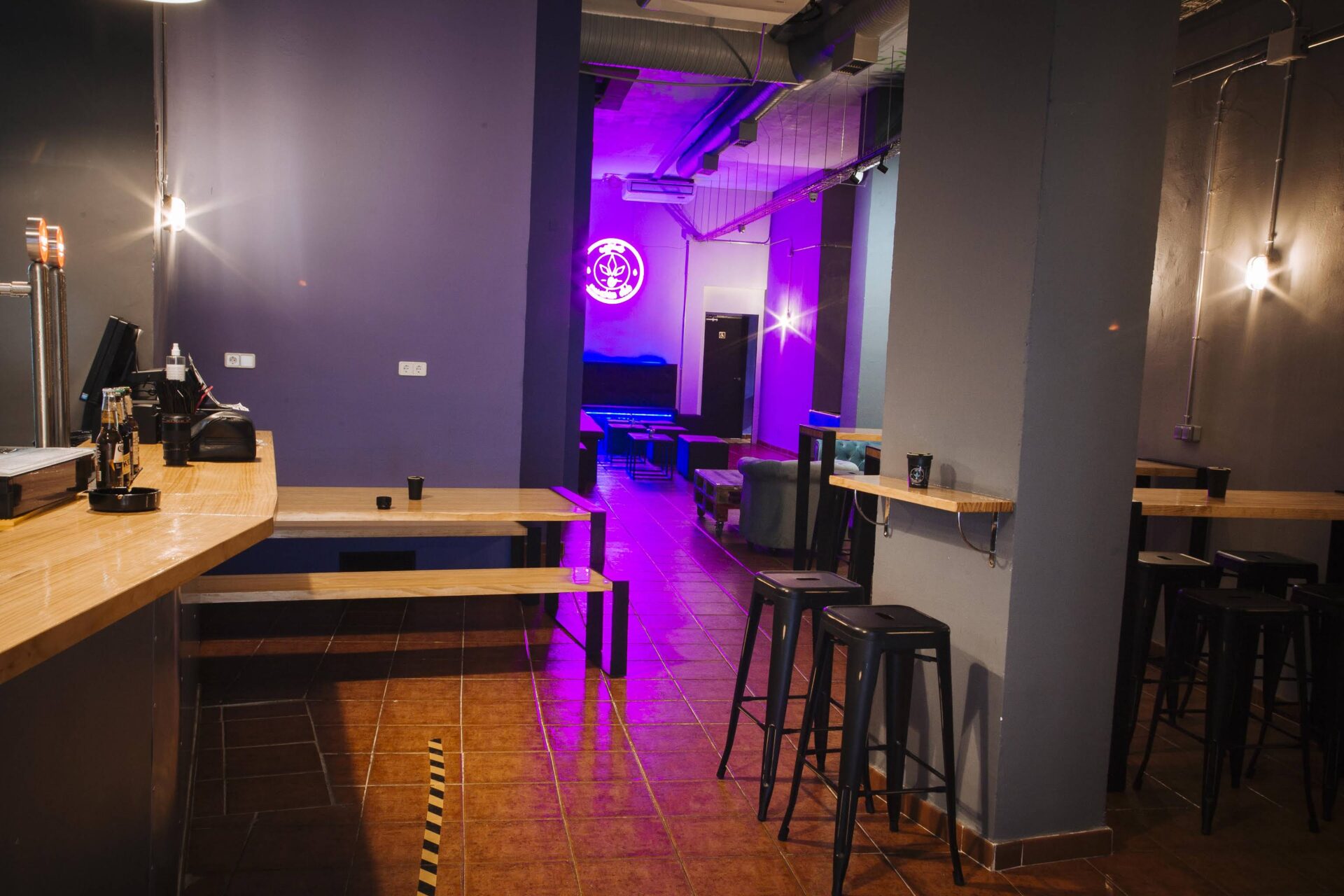 Zone bar et espace assis du club social de cannabis Enjoint à Madrid avec éclairage néon