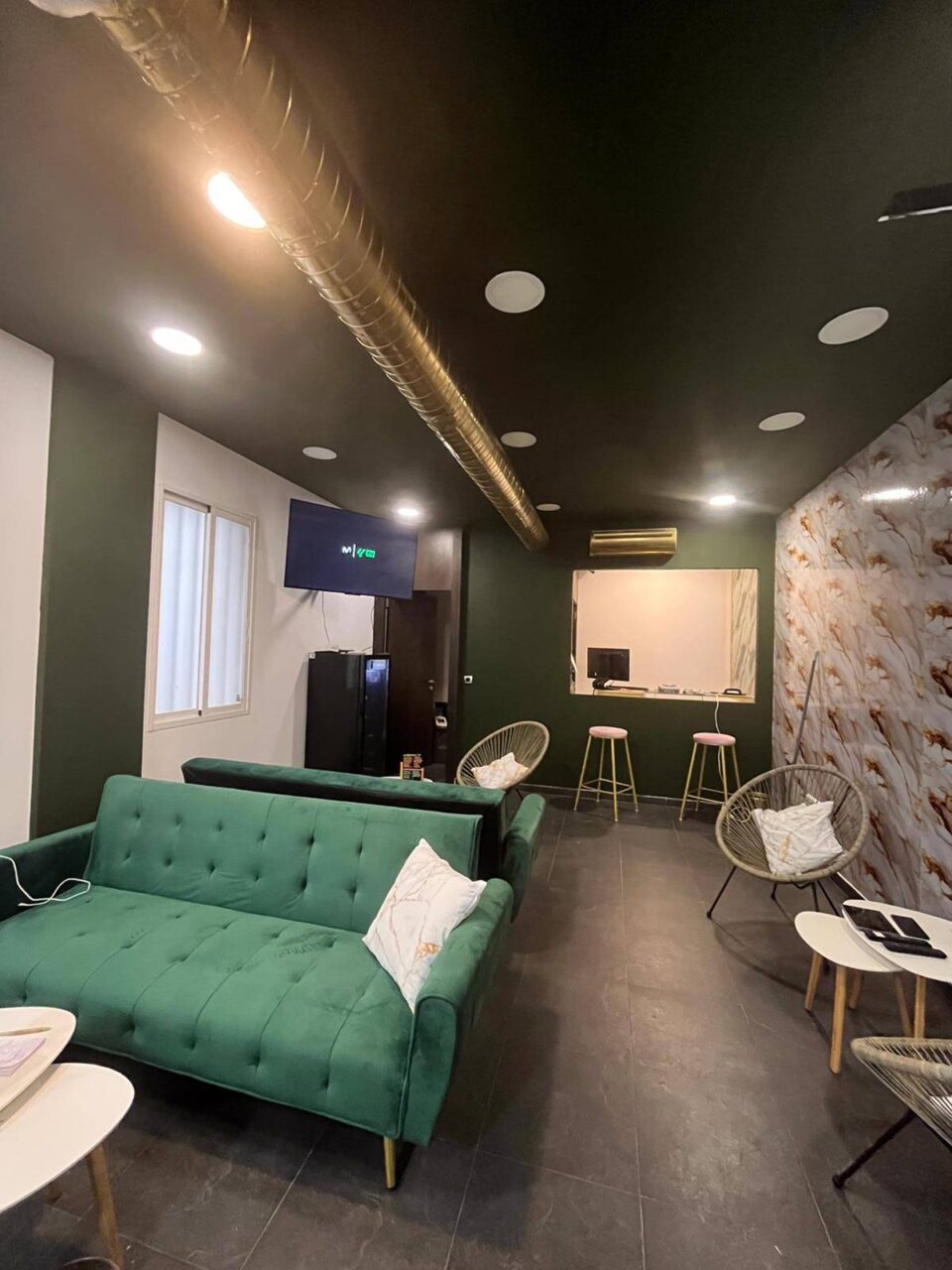 Salle principale du club de cannabis Green Paradise à Madrid avec canapés verts