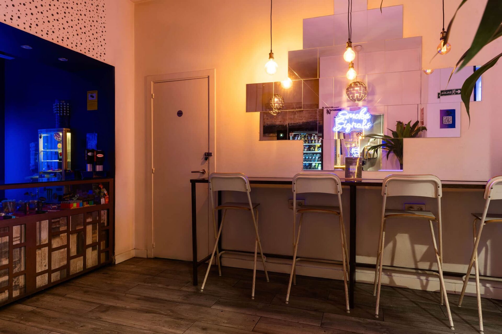 Comptoir avec miroirs et néon au club de cannabis Smoke Signals de Barcelone